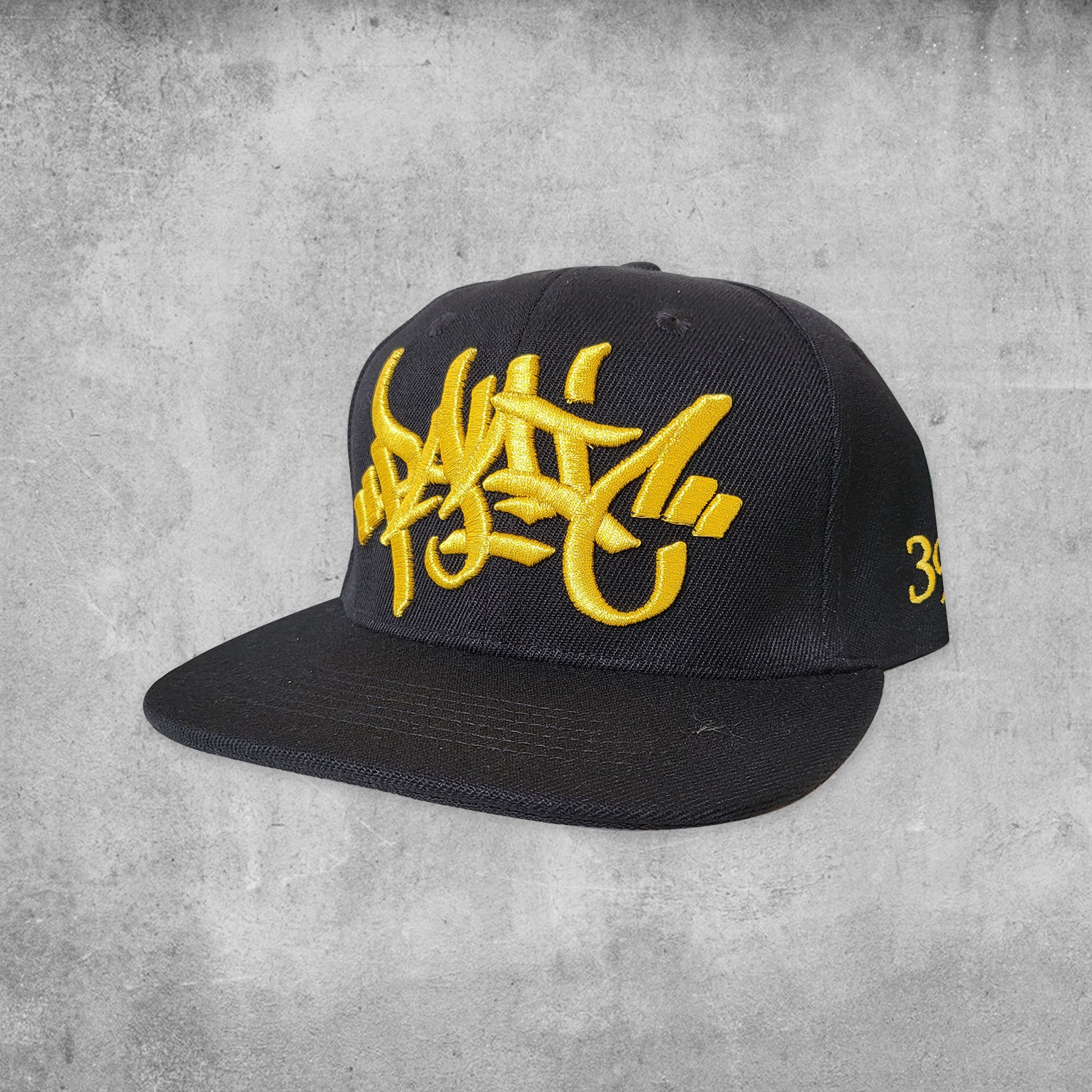 Panic 39 branded snap back hat in black with gold puff embroidery.