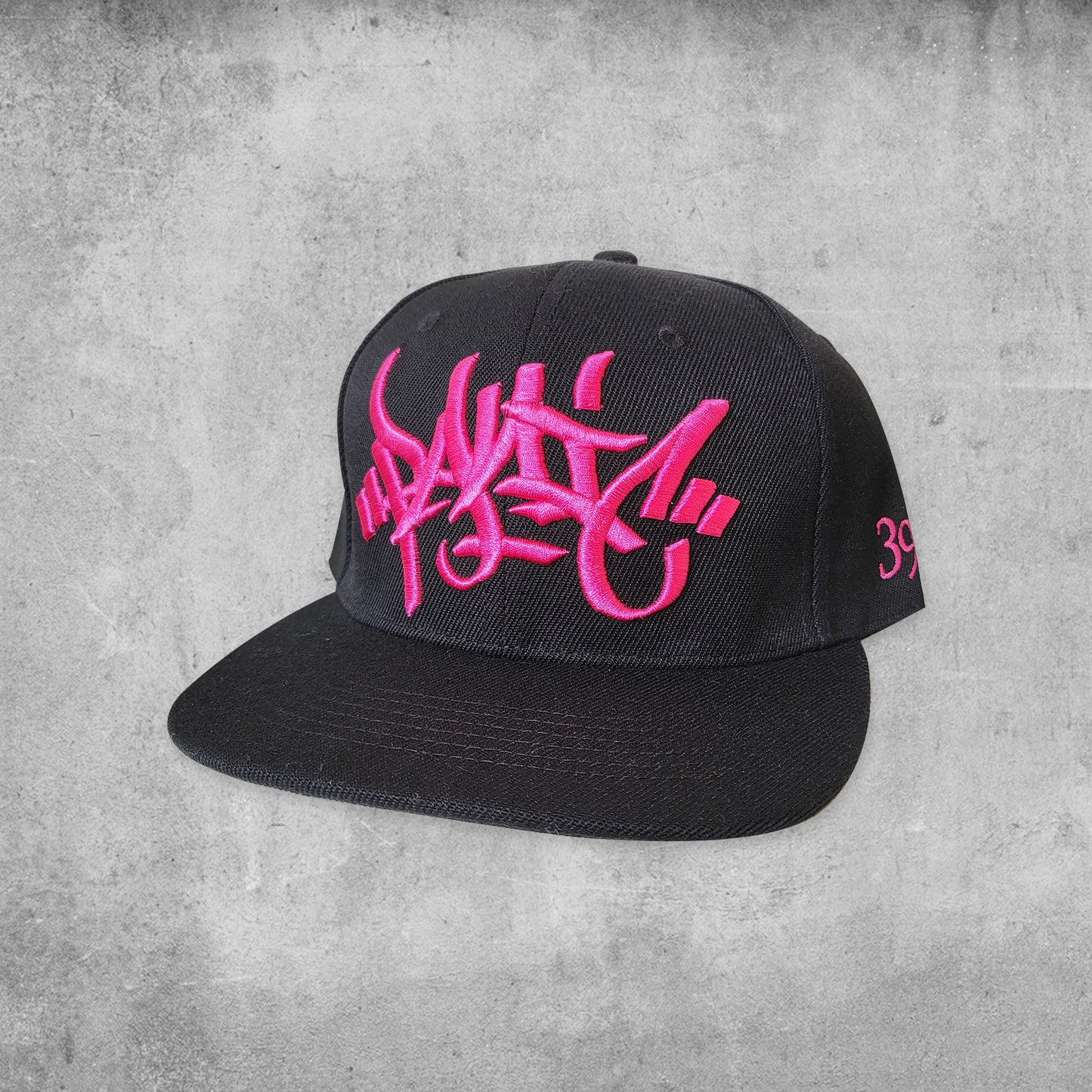 Panic 39 branded snap back hat in black with pink puff embroidery.