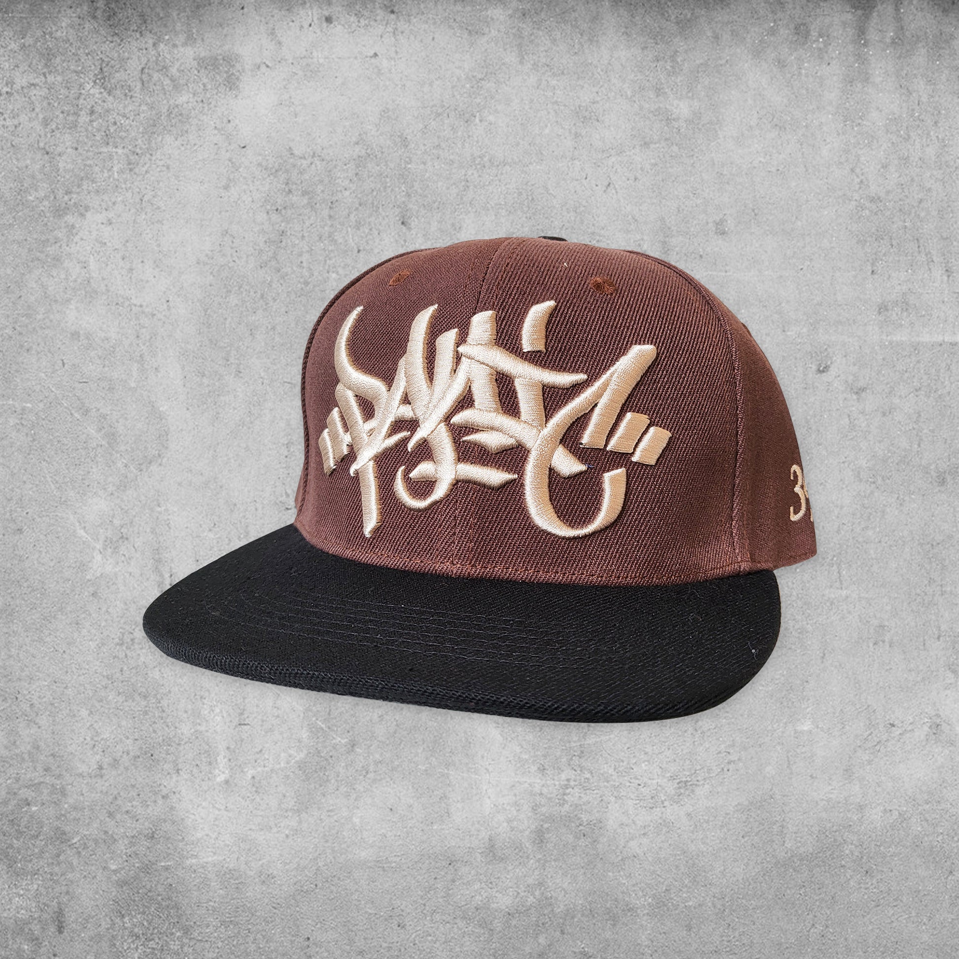 Panic 39 branded snap back hat in brown with cream puff embroidery.
