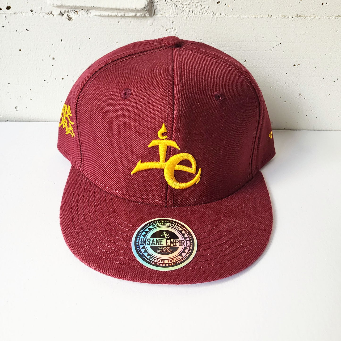 Local graffiti artist clothing brand inland empire gold on maroon red snap back hat