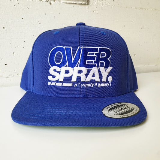 Overspray, small business graffiti shop branded snap back hat in white and blue.