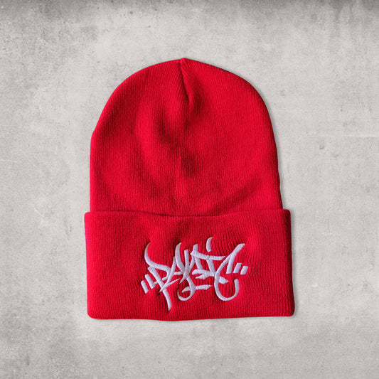 Red beanie hat with white embroidery reading Panic in tag font