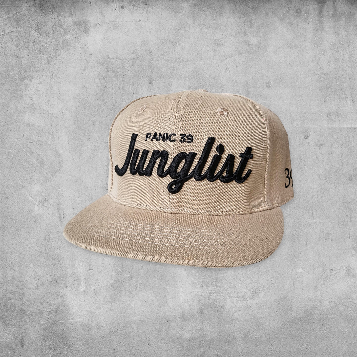Panic 39 branded snap back hat in tan with black puff embroidery.