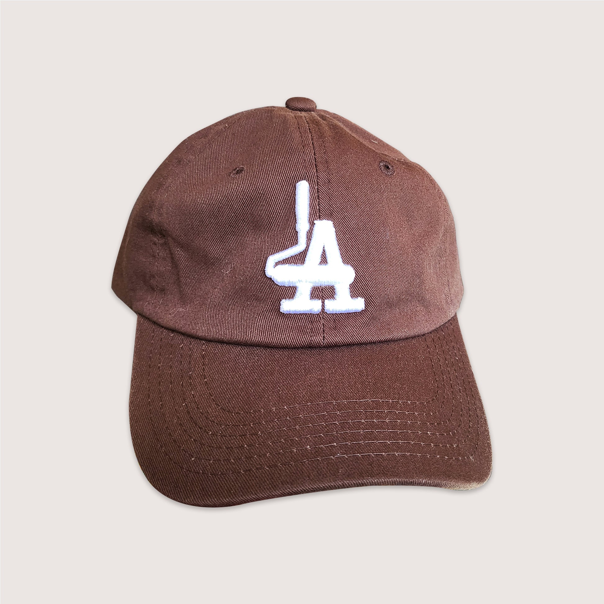 Locally branded unstructured cap in brown with white puff embroidery detail.
